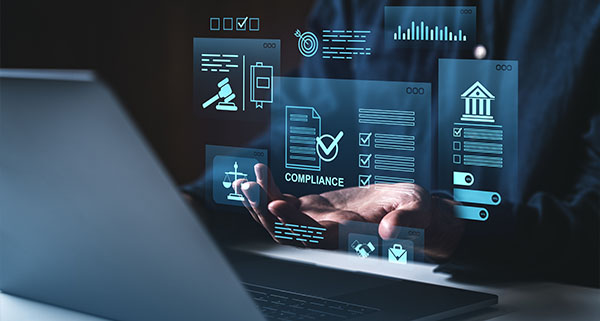 hands gesturing over a laptop displaying compliance technology interface with legal and data icons for business and compliance management