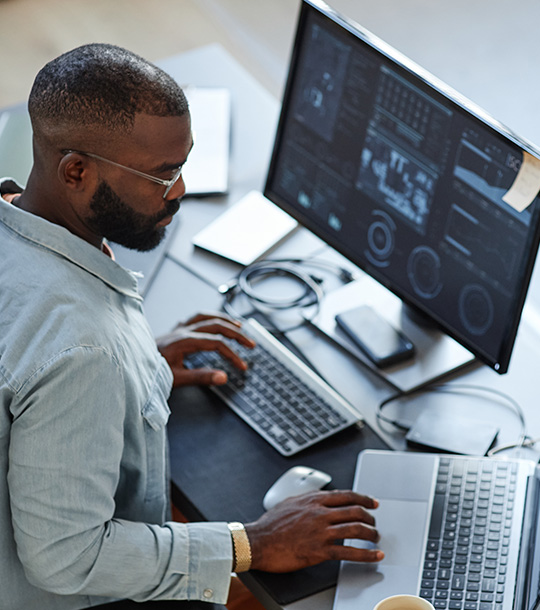 man working on computer with statistics and data analysis displaying on multiple screens focused on modern technology and productivity in the digital age using eight effective strategies for data interpretation